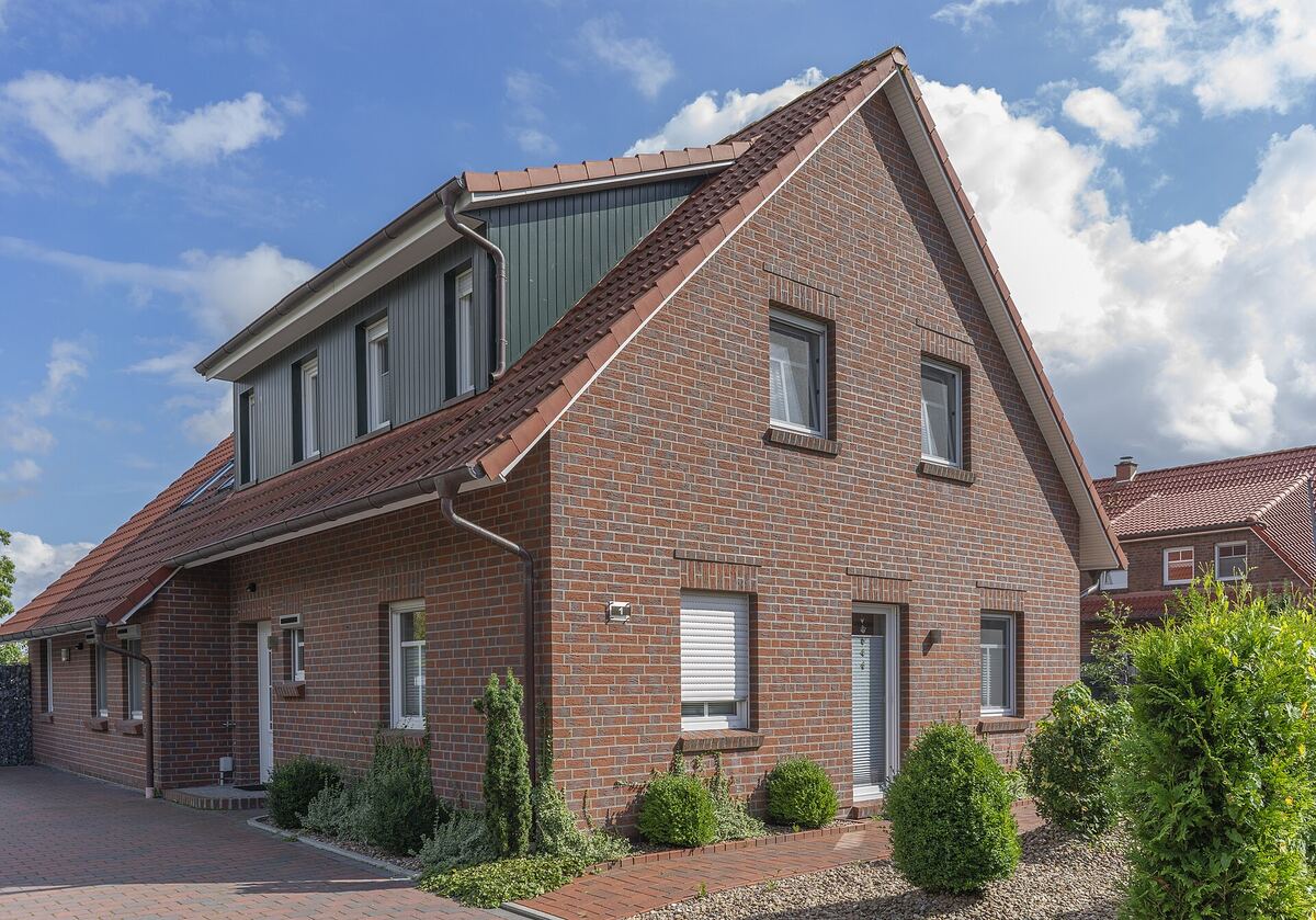 Rood bakstenen vakantiehuis met terras en tuin in een vakantiewijk