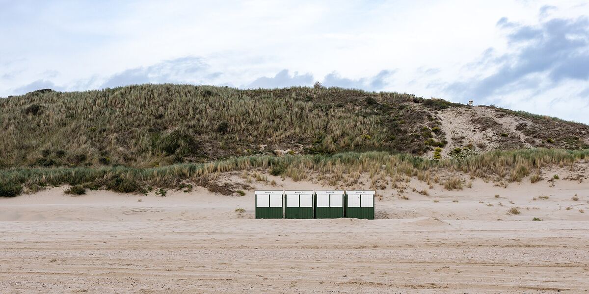 Strandhuisjes op een breed strand voor de duinen van Zoutelande